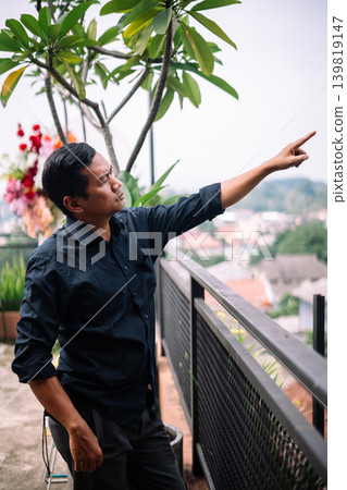 Man in dark shirt pointing at something in the distance Man in dark shirt pointing at something in the distance 139819147