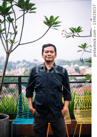 Relaxed Professional Man Posing on a Modern City Rooftop 139819157