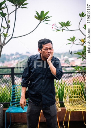 Adult man suffering from painful toothache or severe face pain outdoors Adult man suffering from painful toothache or severe face pain outdoors 139819167
