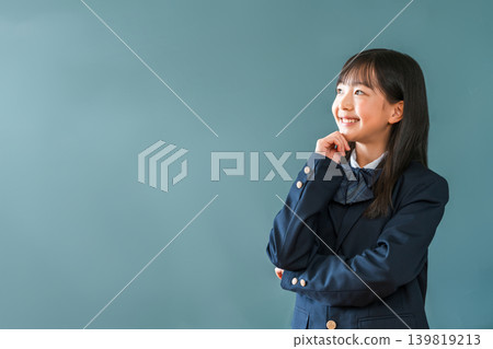 Elementary school, junior high school, and high school girls wearing blazers standing in front of a blackboard and thinking with a smile Elementary school, junior high school, and high school girls wearing blazers standing in front of a blackboard and thinking with a smile 139819213