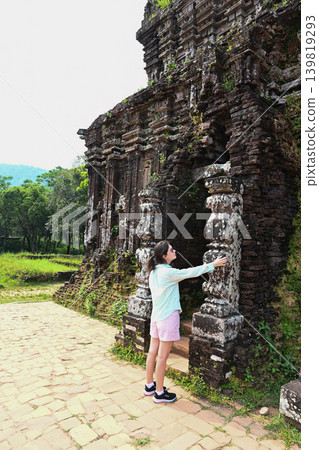 A 30 year old Russian woman tourist touches an ancient stone pillar at My Son sanctuary ruins near Da Nang city in Quang Nam province Vietnam A 30 year old Russian woman tourist touches an ancient stone pillar at My Son sanctuary ruins near Da Nang city in Quang Nam province Vietnam 139819293