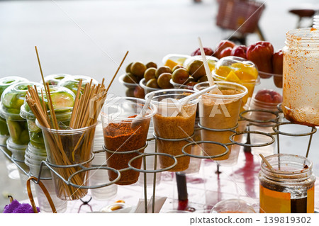 A variety of fresh tropical fruits in plastic cups served with traditional chili salt seasonings at a street food market stall in Hoi An Vietnam A variety of fresh tropical fruits in plastic cups served with traditional chili salt seasonings at a street food market stall in Hoi An Vietnam 139819302