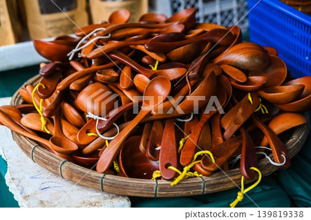 A close up view of traditional handcrafted thia go wooden spoons displayed on a round met tre bamboo tray at a souvenir market stall in Vietnam A close up view of traditional handcrafted thia go wooden spoons displayed on a round met tre bamboo tray at a souvenir market stall in Vietnam 139819338