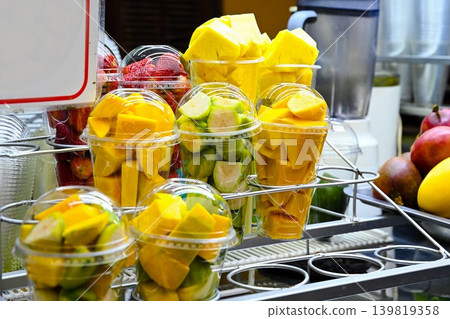 Fresh sliced tropical fruits including mango pineapple guava and strawberry packed in plastic cups for take away street market in Vietnam Fresh sliced tropical fruits including mango pineapple guava and strawberry packed in plastic cups for take away street market in Vietnam 139819358