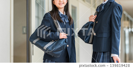 穿著制服的小學生、國中生、高中生和女高中生走在學校走廊裡 139819428