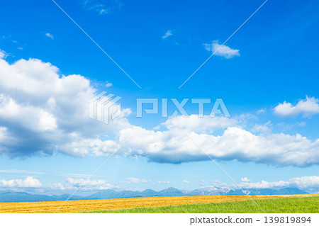 A view of the blue sky and white clouds from a hilltop in Biei, Hokkaido, during the summer. A view of the blue sky and white clouds from a hilltop in Biei, Hokkaido, during the summer. 139819894