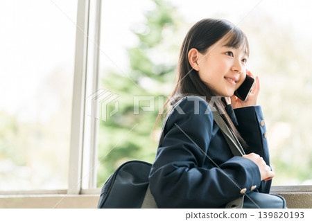 高中生、國中生和小學生用智慧型手機打電話。 高中生、國中生和小學生用智慧型手機打電話。 139820193