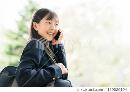 高中生、國中生和小學生用智慧型手機打電話。 高中生、國中生和小學生用智慧型手機打電話。 139820194