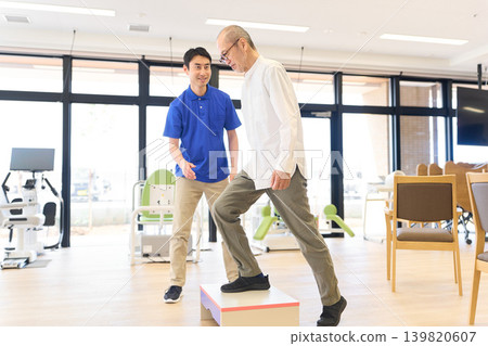 Senior citizen and caregiver performing rehabilitation exercises on a step stool Senior citizen and caregiver performing rehabilitation exercises on a step stool 139820607
