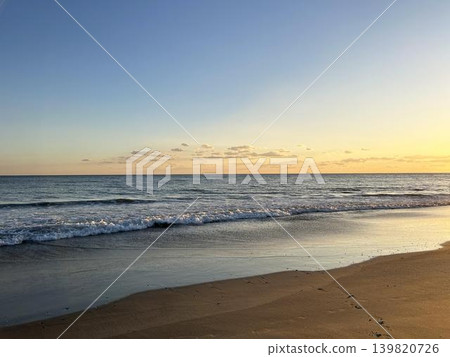 夕陽西下,海浪拍打著沙灘,構成了一幅美麗的畫面。 夕陽西下,海浪拍打著沙灘,構成了一幅美麗的畫面。 139820726