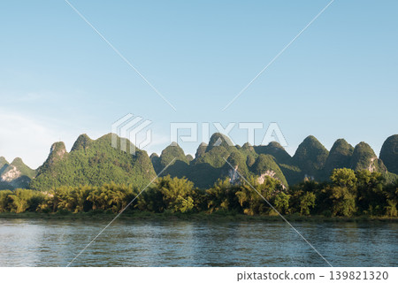 The beautiful river scenery of Guilin and the Li River, and the karst peaks, spread out under a clear blue sky. The beautiful river scenery of Guilin and the Li River, and the karst peaks, spread out under a clear blue sky. 139821320