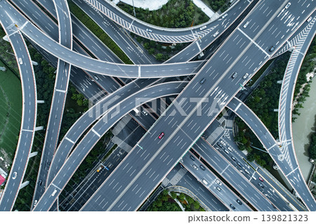A geometric aerial view from directly above, capturing a complex network of intersecting overpasses and junctions. A geometric aerial view from directly above, capturing a complex network of intersecting overpasses and junctions. 139821323