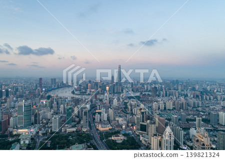 A magnificent aerial view of Shanghai at dusk, overlooking the city skyline, the curve of the Huangpu River, and the cluster of skyscrapers in Lujiazui. A magnificent aerial view of Shanghai at dusk, overlooking the city skyline, the curve of the Huangpu River, and the cluster of skyscrapers in Lujiazui. 139821324