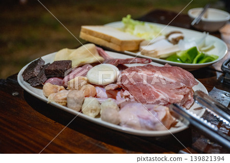 業餘生活傳記：木架上的彭板式烤肉食材，生豬肉塊，肉末，米血，以及圓米飯和蔬菜的製作方法等特別資訊。 139821394