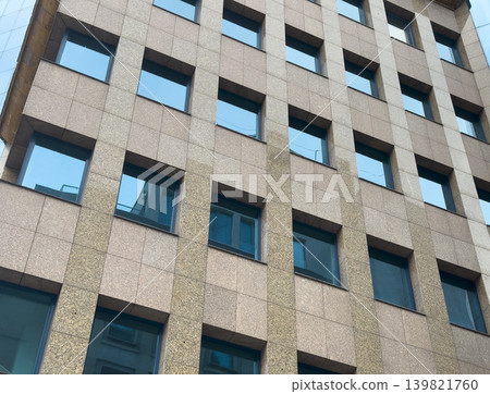 Closeup of modern building exterior with blue windows, concrete facade. Contemporary urban Closeup of modern building exterior with blue windows, concrete facade. Contemporary urban 139821760