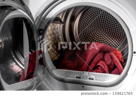 Towel linen lying inside big drum of open dryer, drying machine. Towel linen lying inside big drum of open dryer, drying machine. 139821765