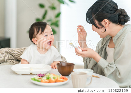 Mother feeding her baby solid food (childcare, parenting, baby biscuits) 139822169