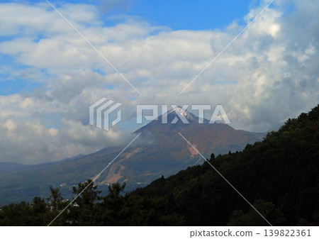 In late autumn, Mount Bandai, lightly capped with snow, and its autumn-colored slopes are surrounded by white clouds, creating a striking and beautiful sight. In late autumn, Mount Bandai, lightly capped with snow, and its autumn-colored slopes are surrounded by white clouds, creating a striking and beautiful sight. 139822361