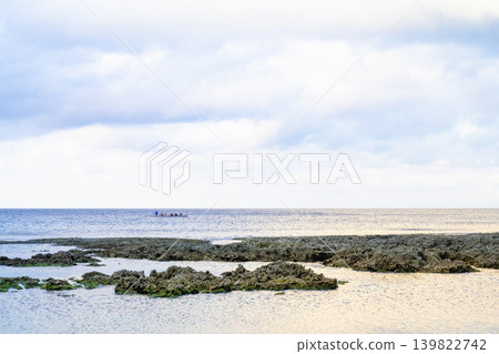 台灣偏遠島嶼風光：一艘小船在太平洋沿岸航行的全景，海蝕珊瑚礁，岩石海岸，以及雲海全景。 139822742