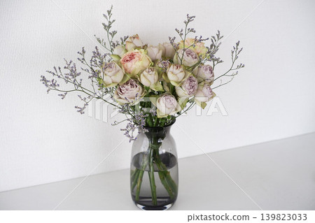 A natural bouquet of antique roses displayed in a glass vase. 139823033