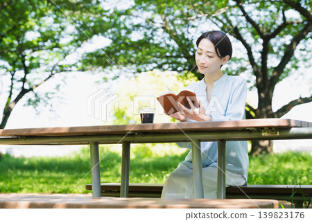 Young woman reading outdoors Lifestyle image Young woman reading outdoors Lifestyle image 139823176