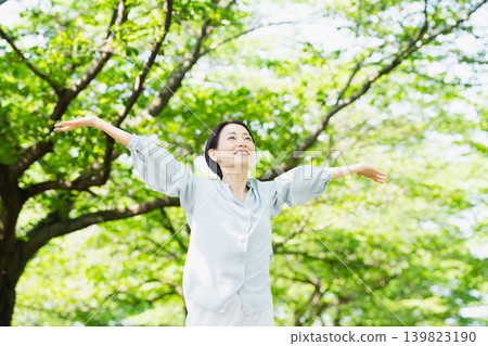 Young woman stretching under a tree Lifestyle image Young woman stretching under a tree Lifestyle image 139823190