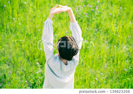Young woman stretching in the grassland Lifestyle image Young woman stretching in the grassland Lifestyle image 139823208