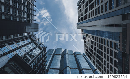 looking up perspective of modern high-rise skyscraper towerr with glass corporate architecture, futuristic urban skyline with towering highrise buildings and geometric city facade background looking up perspective of modern high-rise skyscraper towerr with glass corporate architecture, futuristic urban skyline with towering highrise buildings and geometric city facade background 139823534