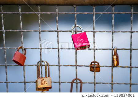 View of colorful old and new padlocks on the iron fence of the bridge View of colorful old and new padlocks on the iron fence of the bridge 139824001