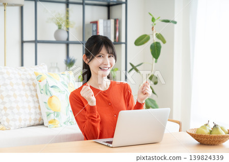 Middle-aged woman using a computer in the living room 139824339
