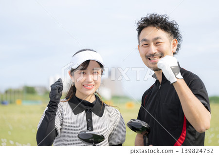 Image of a woman taking a golf lesson, smiling and making a victory pose, looking at the camera with her golf instructor. Image of a woman taking a golf lesson, smiling and making a victory pose, looking at the camera with her golf instructor. 139824732