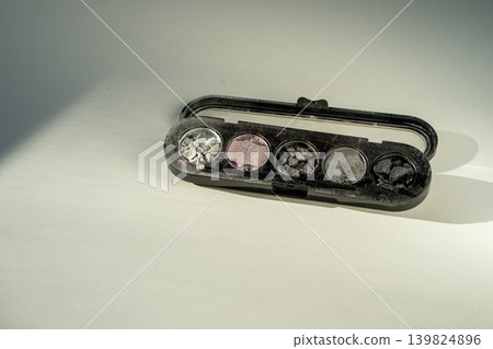Broken eyeshadow palettes on a white table. Decorative cosmetics Broken eyeshadow palettes on a white table. Decorative cosmetics 139824896