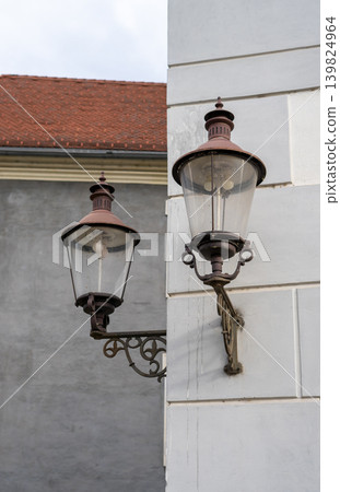 View of antique wall-mounted street lanterns on a stone wall of a house 139824964