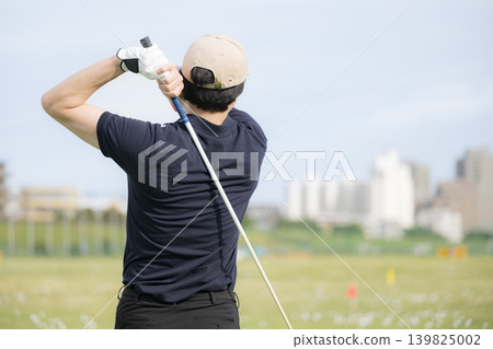 一張充滿運動氣息的圖片,圖片中一位男性高爾夫球手正在練習場揮桿擊球(沒有露臉)。 一張充滿運動氣息的圖片,圖片中一位男性高爾夫球手正在練習場揮桿擊球(沒有露臉)。 139825002