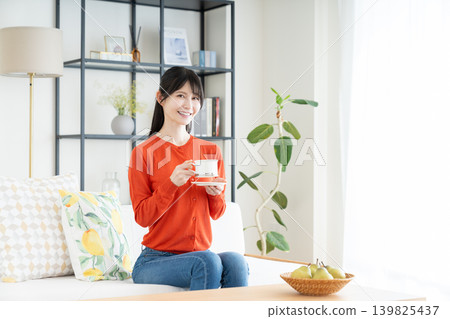 Middle woman drinking coffee in the living room Middle woman drinking coffee in the living room 139825437