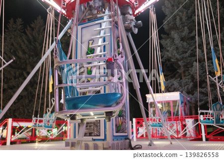 Empty seats on the illuminated carnival ride. Located at an outdoor event 139826558