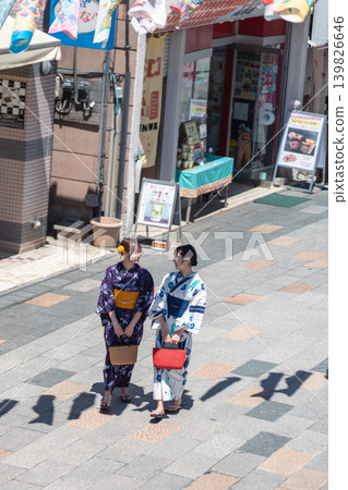 A woman in a yukata (summer kimono) sightseeing in Koedo Kawagoe, with a panoramic view of the traditional storehouse-style townscape. A woman in a yukata (summer kimono) sightseeing in Koedo Kawagoe, with a panoramic view of the traditional storehouse-style townscape. 139826646