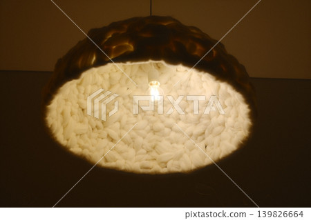 A lamp hangs, casting upward light 139826664