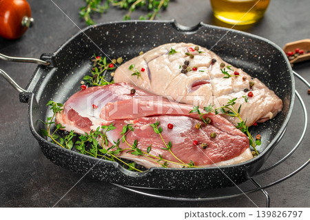 Duck meat in grill pan with herbs and pepper on dark background Duck meat in grill pan with herbs and pepper on dark background 139826797
