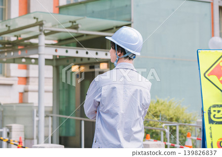 The back view of the site supervisor standing at the construction site. The back view of the site supervisor standing at the construction site. 139826837