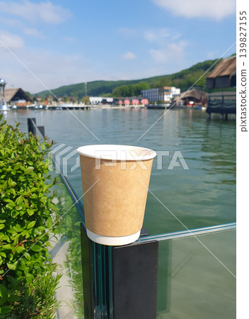 Paper Coffee Cup by Waterfront on Sunny Day 139827155