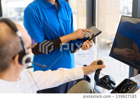 Foreign caregiver manages exercise using tablet Foreign caregiver manages exercise using tablet 139827185
