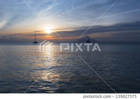 Coastal landscape with silhouettes of distant boats Coastal landscape with silhouettes of distant boats 139827375