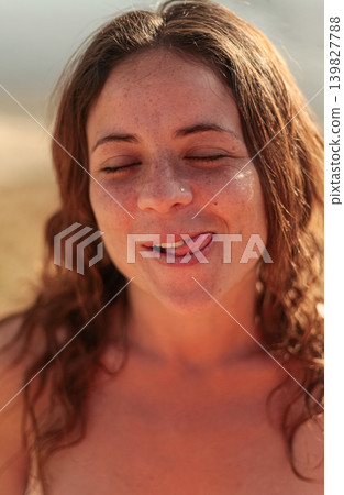 Smiling young woman with closed eyes enjoying golden hour by a marsh 139827788