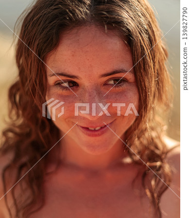 Smiling girl at sunset by a calm wetland landscape in warm evening light 139827790