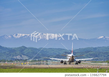 陽光明媚的仙台機場:藏王山脈和一架正在起飛的飛機。宮城縣名取市。 陽光明媚的仙台機場:藏王山脈和一架正在起飛的飛機。宮城縣名取市。 139827794