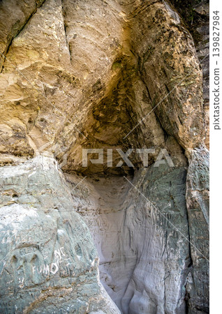 Sandstone rocks surround a river trail in Gauja National Park in Latvia with forest nearby. Sandstone rocks surround a river trail in Gauja National Park in Latvia with forest nearby. 139827984