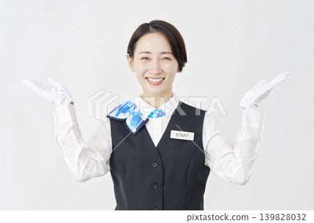 Female staff member pointing left and right with her palms; receptionist/bus guide; white background. Female staff member pointing left and right with her palms; receptionist/bus guide; white background. 139828032