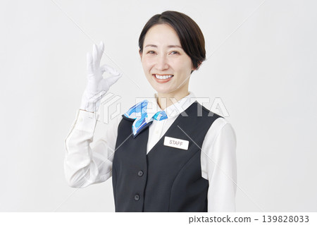 Female staff member, receptionist/bus guide, OK sign, white background. Female staff member, receptionist/bus guide, OK sign, white background. 139828033