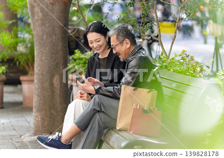 Couple shopping on a bench Couple shopping on a bench 139828178